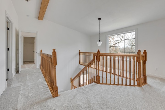 corridor featuring vaulted ceiling with beams, carpet, an upstairs landing, and baseboards