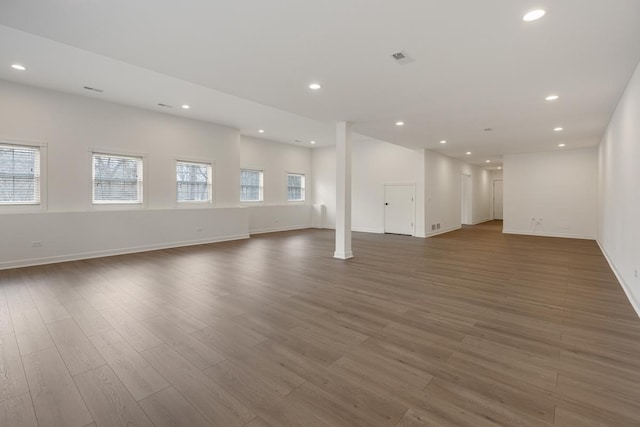 unfurnished living room with baseboards, wood finished floors, visible vents, and recessed lighting