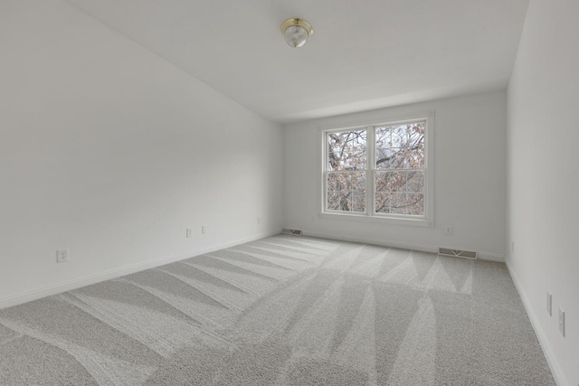 carpeted empty room with visible vents and baseboards