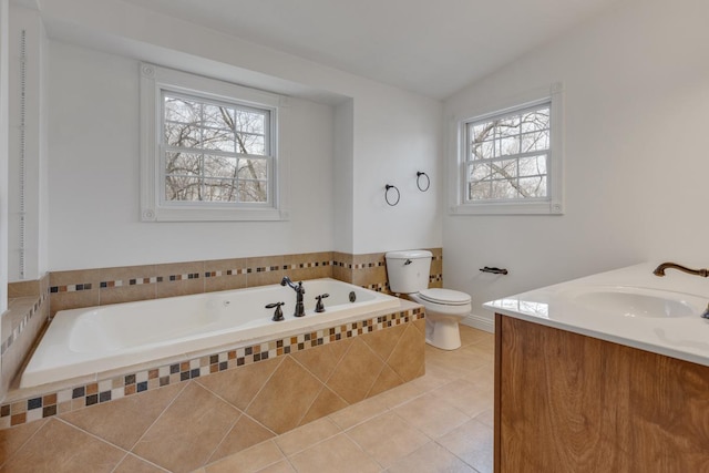 bathroom featuring toilet, a garden tub, tile patterned flooring, vaulted ceiling, and vanity