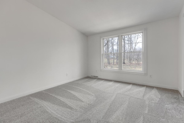 unfurnished room with light carpet, baseboards, visible vents, and lofted ceiling