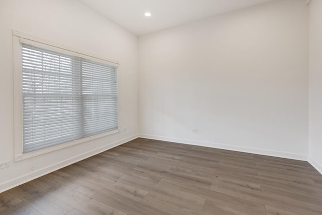 spare room featuring baseboards, wood finished floors, and recessed lighting