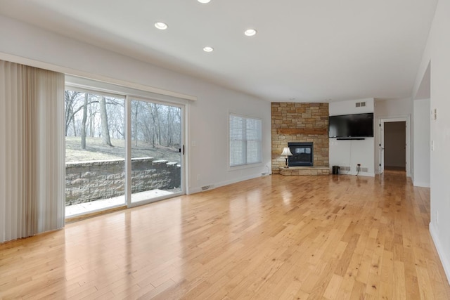 unfurnished living room with recessed lighting, light wood-style flooring, visible vents, and a stone fireplace