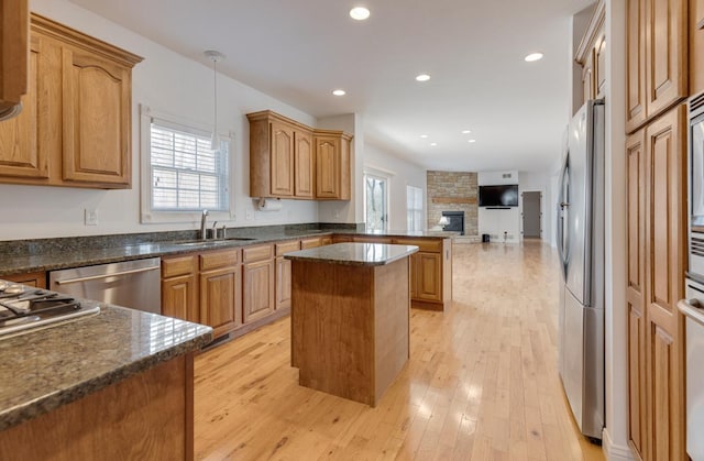 kitchen with open floor plan, appliances with stainless steel finishes, plenty of natural light, and a sink