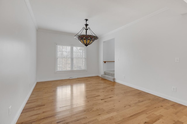 unfurnished dining area with light wood-type flooring, crown molding, baseboards, and stairs