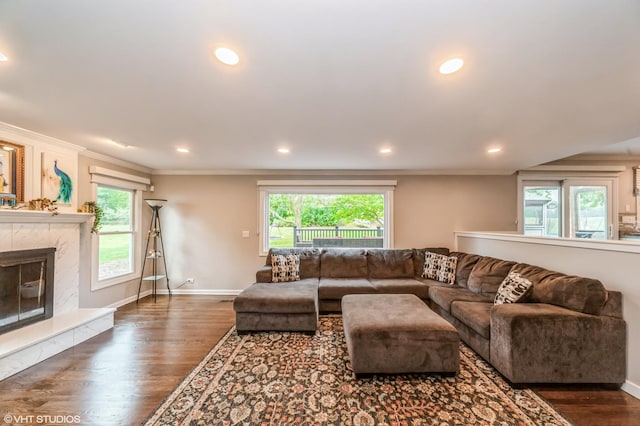 living area with recessed lighting, dark wood-style flooring, a wealth of natural light, and a tile fireplace