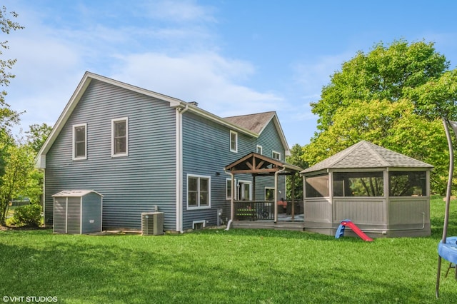 rear view of house featuring central AC, a lawn, and a sunroom