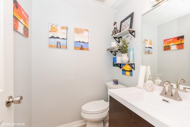 bathroom with visible vents, vanity, toilet, and baseboards