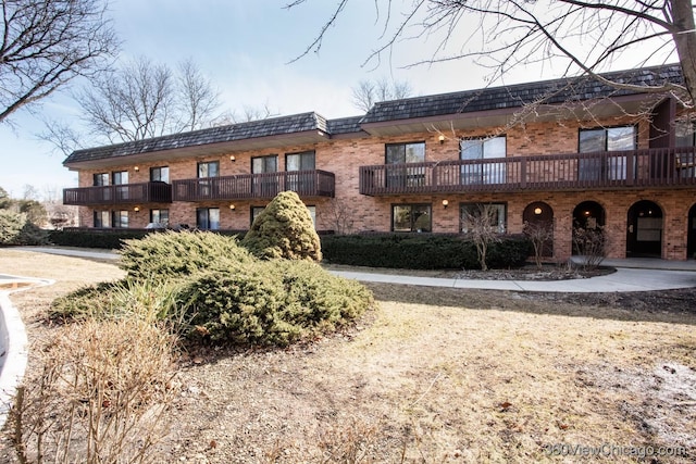 view of front of property featuring brick siding and mansard roof