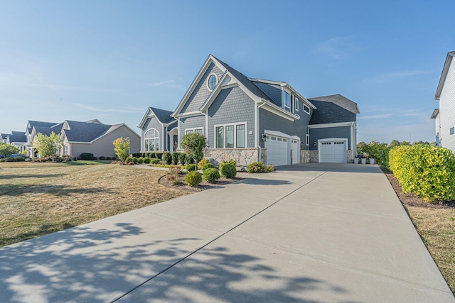 view of front of house featuring stone siding, an attached garage, and concrete driveway