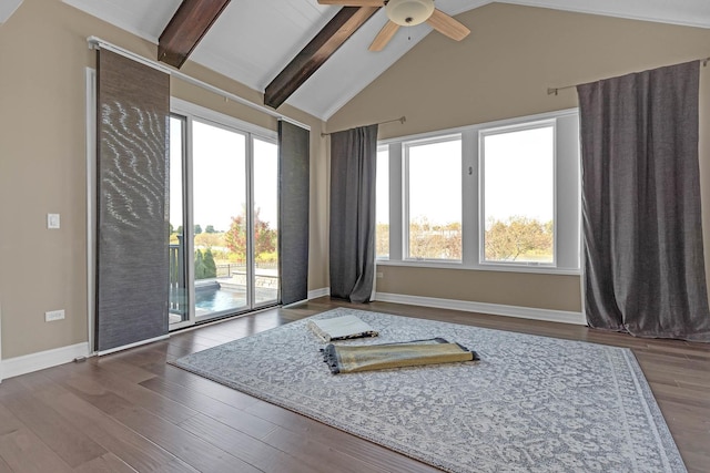 empty room with lofted ceiling with beams, ceiling fan, wood finished floors, and baseboards