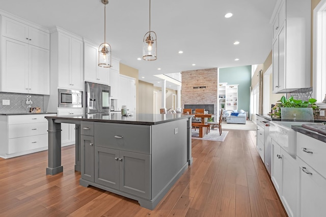 kitchen with stainless steel appliances, dark countertops, gray cabinets, and white cabinetry