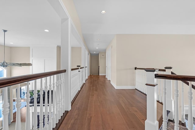 hall featuring recessed lighting, baseboards, an upstairs landing, and wood finished floors