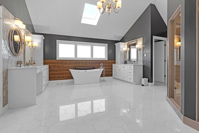 bathroom with a skylight, two vanities, a freestanding bath, tile patterned floors, and a stall shower