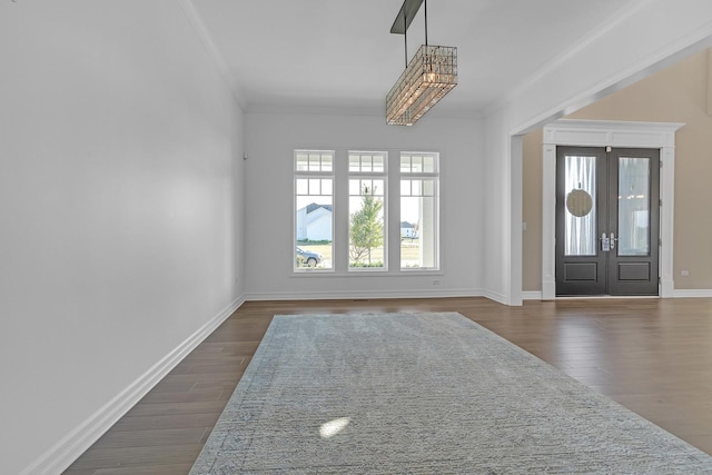 entrance foyer with dark wood-type flooring, french doors, crown molding, and baseboards