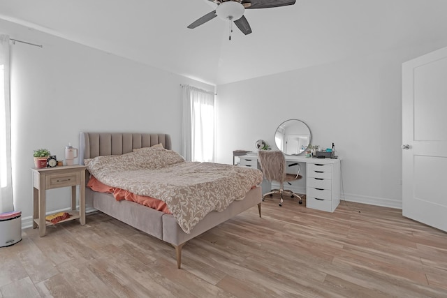 bedroom featuring a ceiling fan, radiator, vaulted ceiling, and light wood finished floors