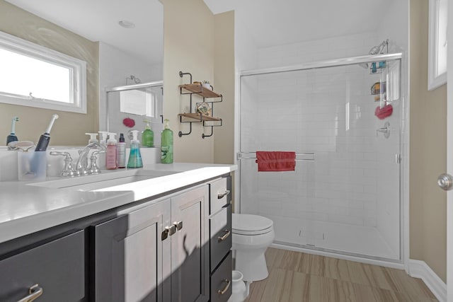 bathroom with vanity, a shower stall, and toilet