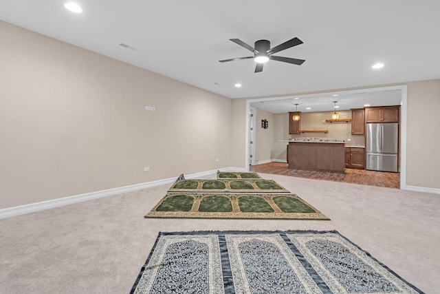 unfurnished living room featuring recessed lighting, light colored carpet, ceiling fan, and baseboards