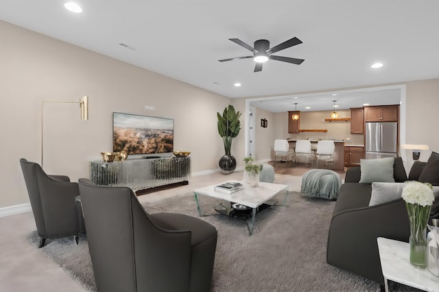 living room featuring ceiling fan, baseboards, and recessed lighting