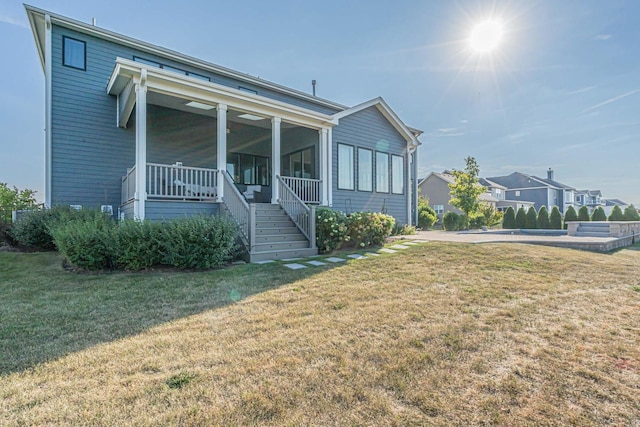 view of front of house featuring a front yard, covered porch, and stairs