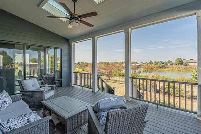 sunroom / solarium with a water view, plenty of natural light, vaulted ceiling, and a ceiling fan