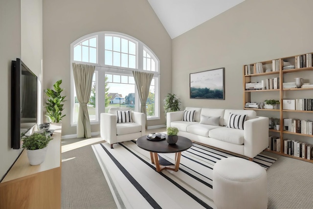 living area with high vaulted ceiling, carpet flooring, and baseboards