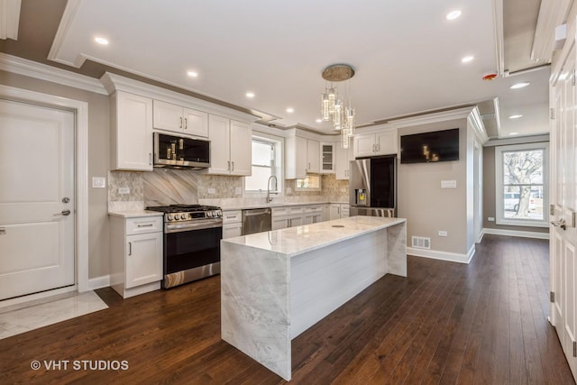 kitchen with visible vents, appliances with stainless steel finishes, white cabinetry, and decorative backsplash