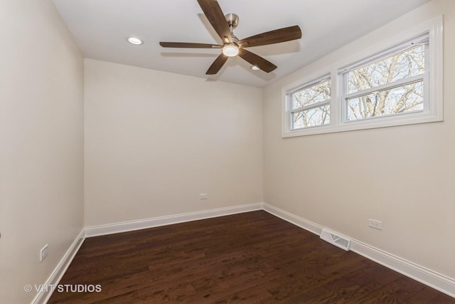 empty room featuring dark wood finished floors, visible vents, recessed lighting, and baseboards