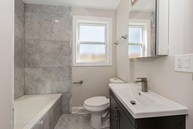 bathroom featuring toilet, marble finish floor, a tub, baseboards, and vanity