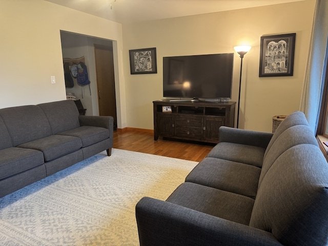 living area with baseboards and wood finished floors