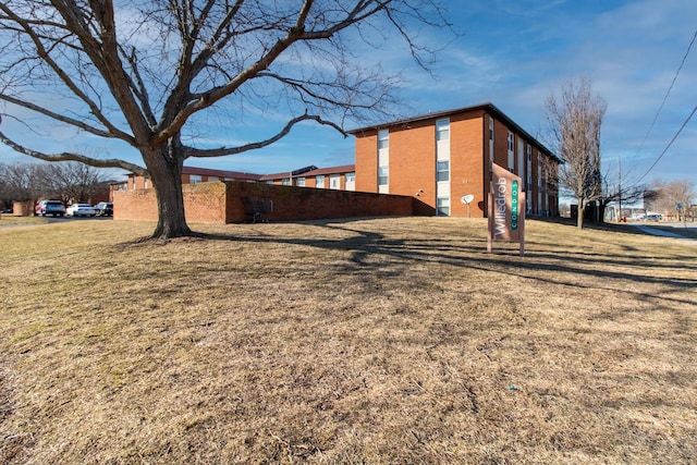 view of home's exterior with brick siding and a yard