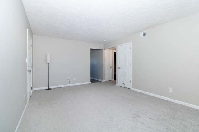 spare room with visible vents, baseboards, and a textured ceiling