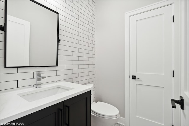 half bath with toilet, decorative backsplash, tile walls, and vanity