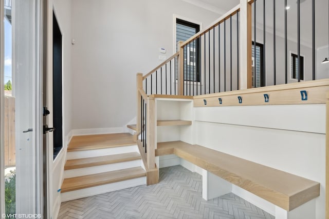 stairs featuring crown molding, a wealth of natural light, and baseboards