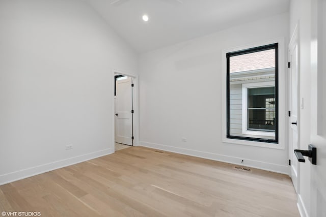 empty room featuring baseboards, visible vents, light wood-type flooring, high vaulted ceiling, and recessed lighting