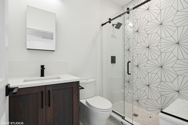 bathroom with a stall shower, vanity, and toilet