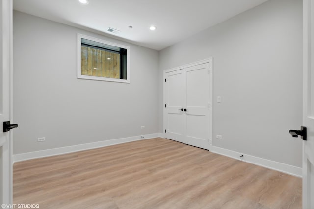 unfurnished room with light wood-type flooring, baseboards, visible vents, and recessed lighting