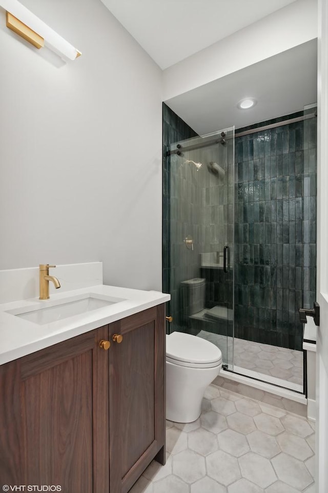 full bath featuring a stall shower, tile patterned flooring, vanity, and toilet