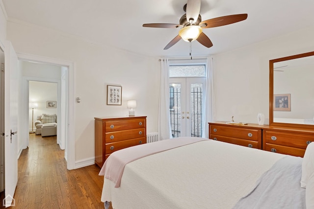 bedroom featuring ceiling fan, access to exterior, french doors, hardwood / wood-style floors, and radiator heating unit