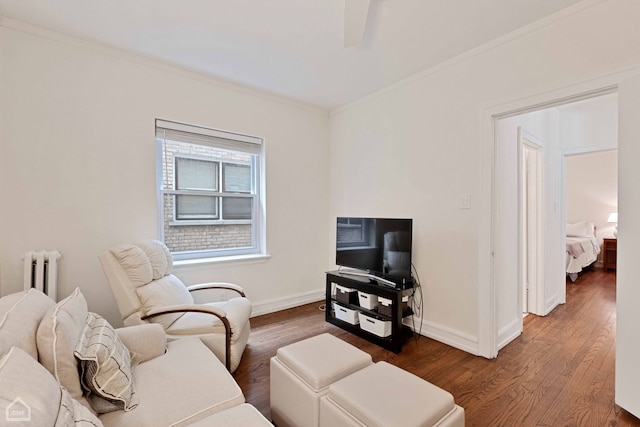 living room with radiator, baseboards, and wood finished floors