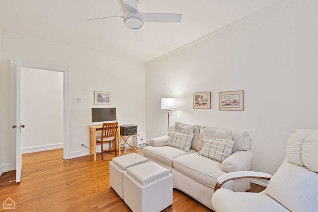 living area featuring light wood-style floors, ceiling fan, and baseboards