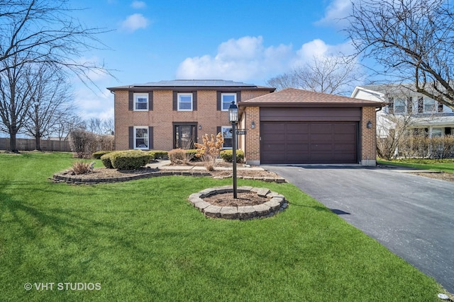 view of front of house featuring an attached garage, a front lawn, aphalt driveway, brick siding, and roof mounted solar panels