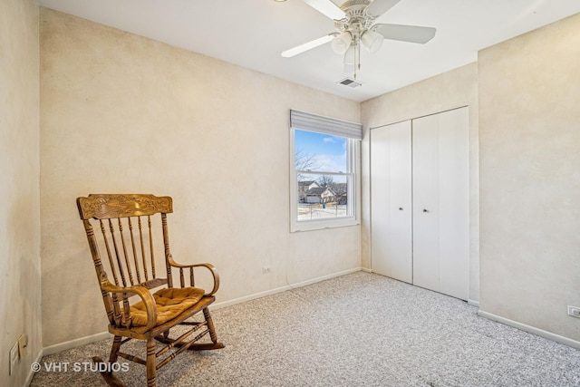 living area featuring visible vents, baseboards, carpet, and a ceiling fan