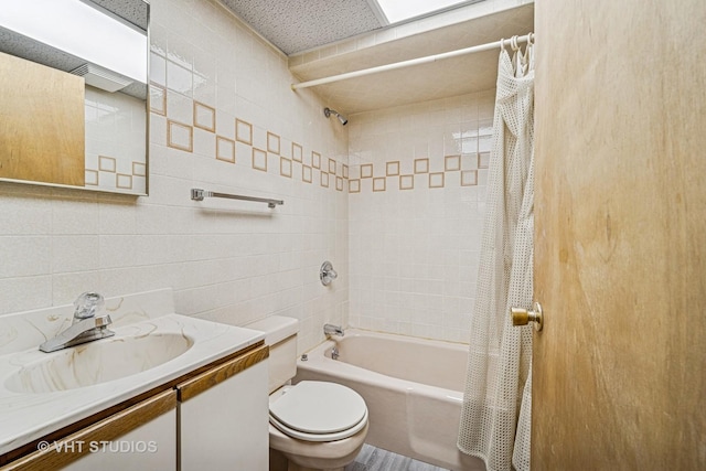 full bathroom with shower / bathtub combination with curtain, toilet, tile walls, and vanity