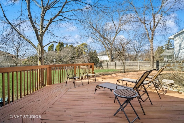 wooden deck with a fenced backyard