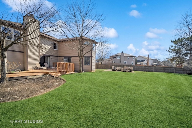 view of yard with a wooden deck and a fenced backyard