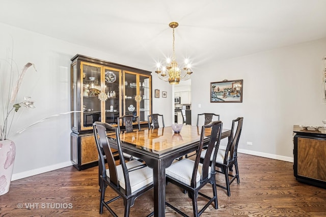 dining space featuring baseboards, a notable chandelier, and dark wood-style flooring