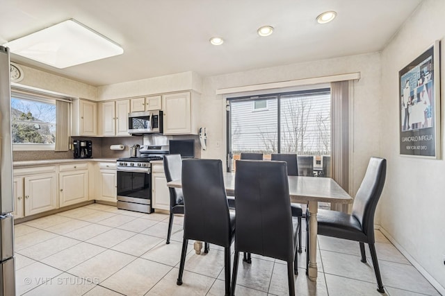 interior space featuring recessed lighting, stainless steel appliances, light tile patterned flooring, light countertops, and baseboards