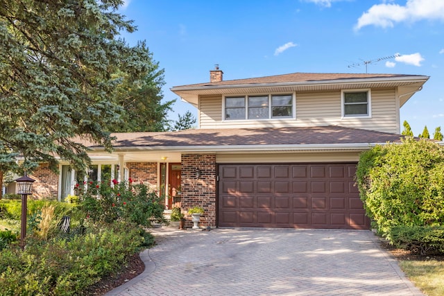 view of front of home featuring a garage, decorative driveway, brick siding, and a chimney