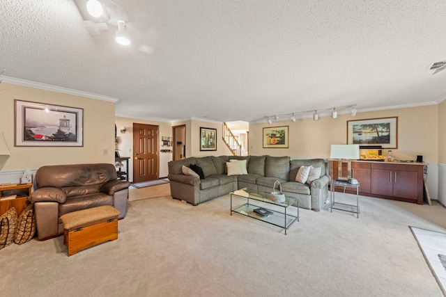 carpeted living area featuring crown molding, visible vents, rail lighting, stairway, and a textured ceiling